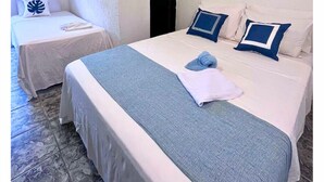 A hotel room with a large bed, two bedside tables, a window, and a door. - VEREDA 7 SUITES (São Sebastião)