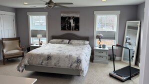 A bedroom with a bed, a chair, a treadmill, a dresser, and a mirror. - Handicapped- Accessible, Family-Friendly Home near UVA (Charlottesville)