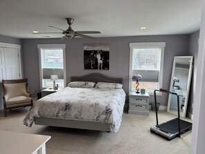 A bedroom with a bed, a chair, a treadmill, a dresser, and a mirror. - Handicapped- Accessible, Family-Friendly Home near UVA (Charlottesville)