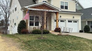 A two-story house with a covered porch, a garage, and a well-maintained lawn. - Handicapped- Accessible, Family-Friendly Home near UVA (Charlottesville)