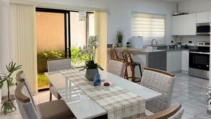 A modern kitchen with white cabinets, a microwave, and a stove.