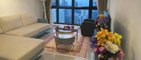 Habitación Deluxe con 1 cama matrimonial o 2 individuales, vista a la ciudad | Área de sala de estar | Televisión LED de 55 pulgadas con canales vía satélite y Netflix