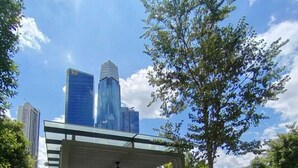 A covered outdoor seating area with a view of tall buildings in the background. - Agile Grand Prime  suite TRX by KL (Kuala Lumpur)