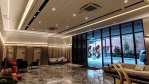 A spacious lobby with a marble floor, modern seating, and large windows offering a view of the street. - Agile Grand Prime  suite TRX by KL (Kuala Lumpur)