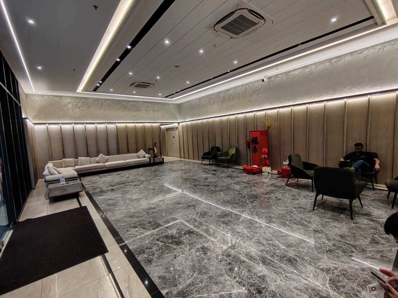 Una habitación amplia con una zona de estar grande, un sofá, sillas y un armario rojo.