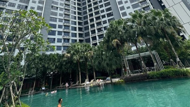 A high-rise building with multiple floors, a swimming pool, and palm trees. - Agile Grand Prime  suite TRX by KL (Kuala Lumpur)
