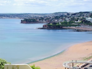 A coastal view with a beach, a cliff, and a town in the background. - Number 1 Marina Court (Torquay)