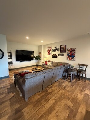 Een moderne woonkamer met een modulaire bank, een flatscreen televisie en een salontafel.