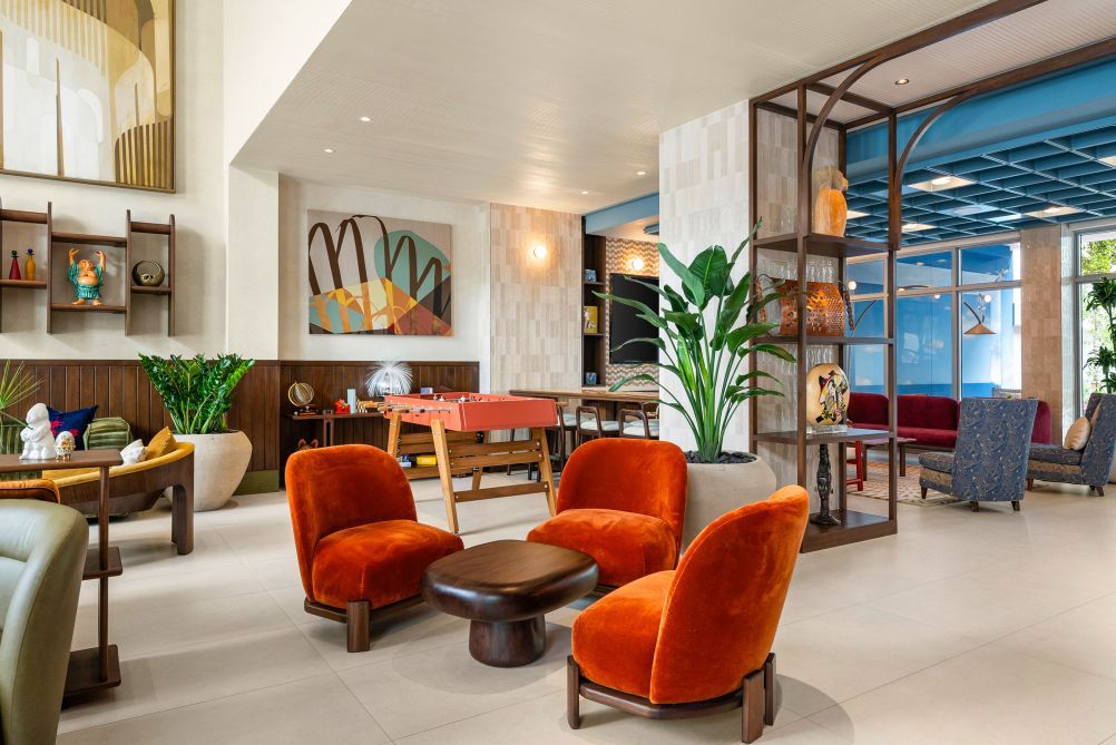 A modern lobby with seating, a pool table, and a large abstract painting.