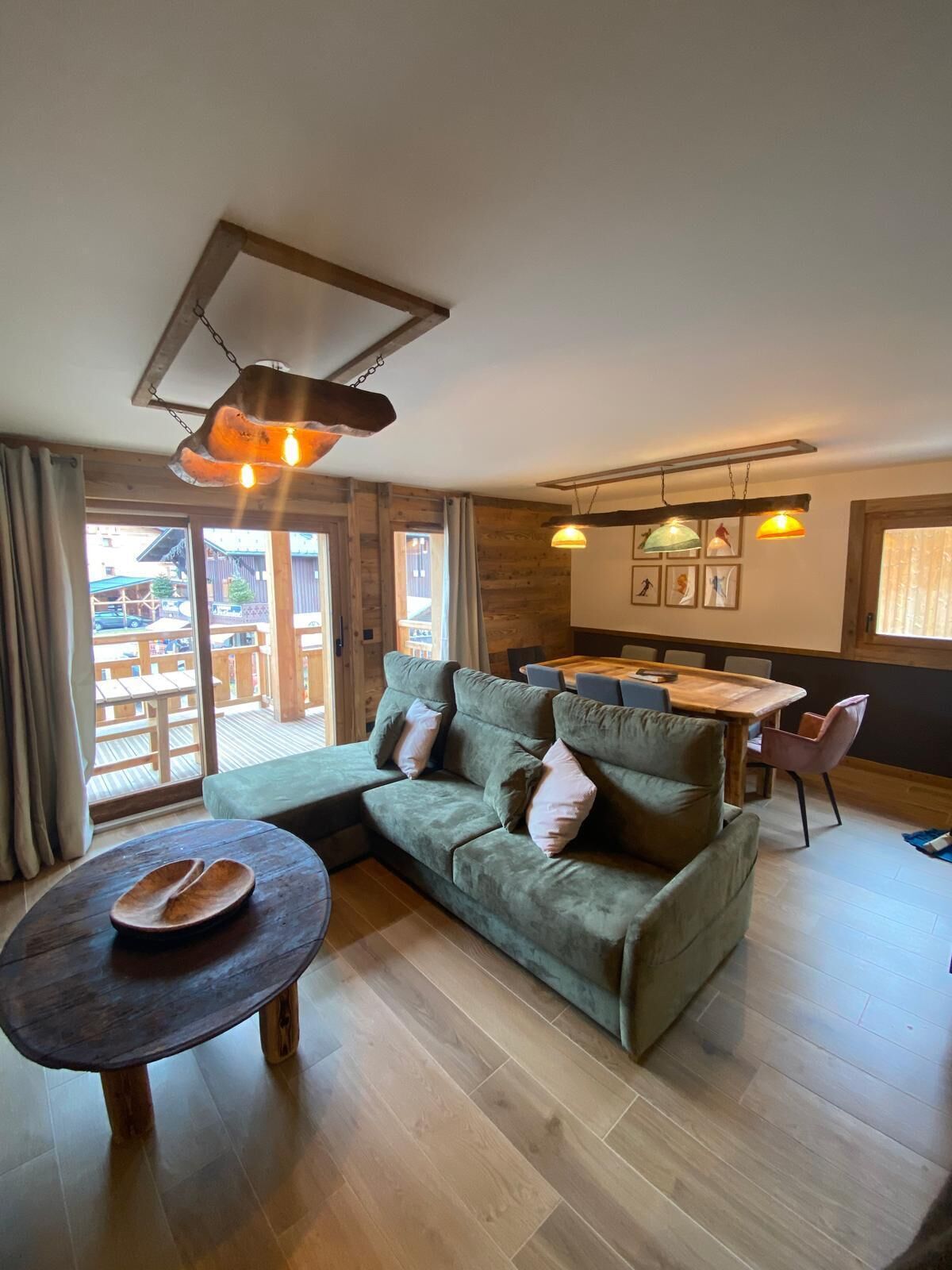 Una sala de estar acogedora con un sofá modular, una mesa de centro de madera y una zona de comedor con mesa y sillas.