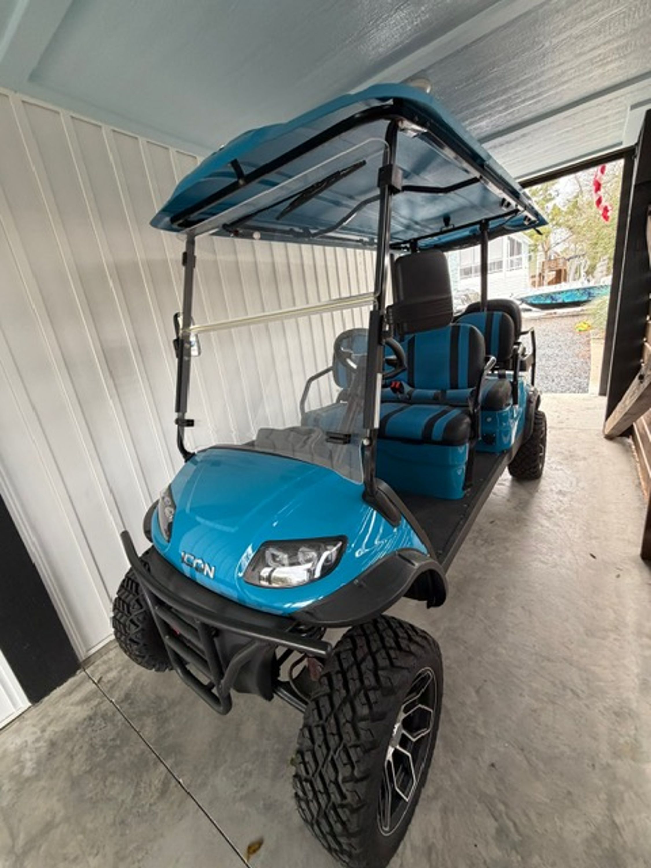A blue golf cart parked inside a garage.