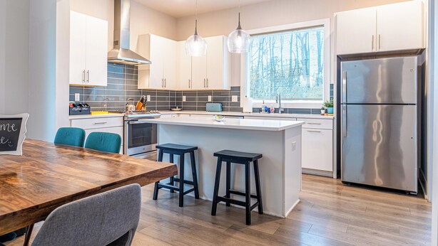 A modern kitchen with a central island, stainless steel appliances, and pendant lighting. - Quiet Charlotte Home, Sleeps 8, Near Uptown (Charlotte)