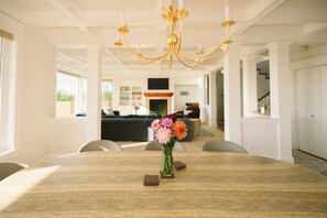 A spacious dining area with a marble table, a chandelier, and a vase of flowers. - Ocean-View Spa Home / Sauna · Cold Plunge · Hot Tub / Sleeps 10 (Long Beach)