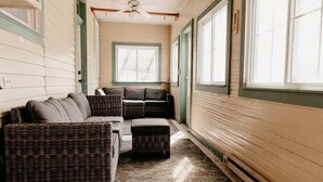 A room with a wicker sofa, a matching ottoman, and a ceiling fan. - The Martin House | Family Getaway Near Shawnee (Elizabethtown)