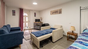 Une chambre à coucher avec un lit, un canapé, un bureau et une télévision.