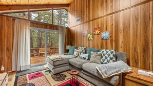 A cozy living room with a sectional sofa, a small coffee table, and a rug with a deer design. - Mama Bear's Cozy Cabin (Sugarloaf)