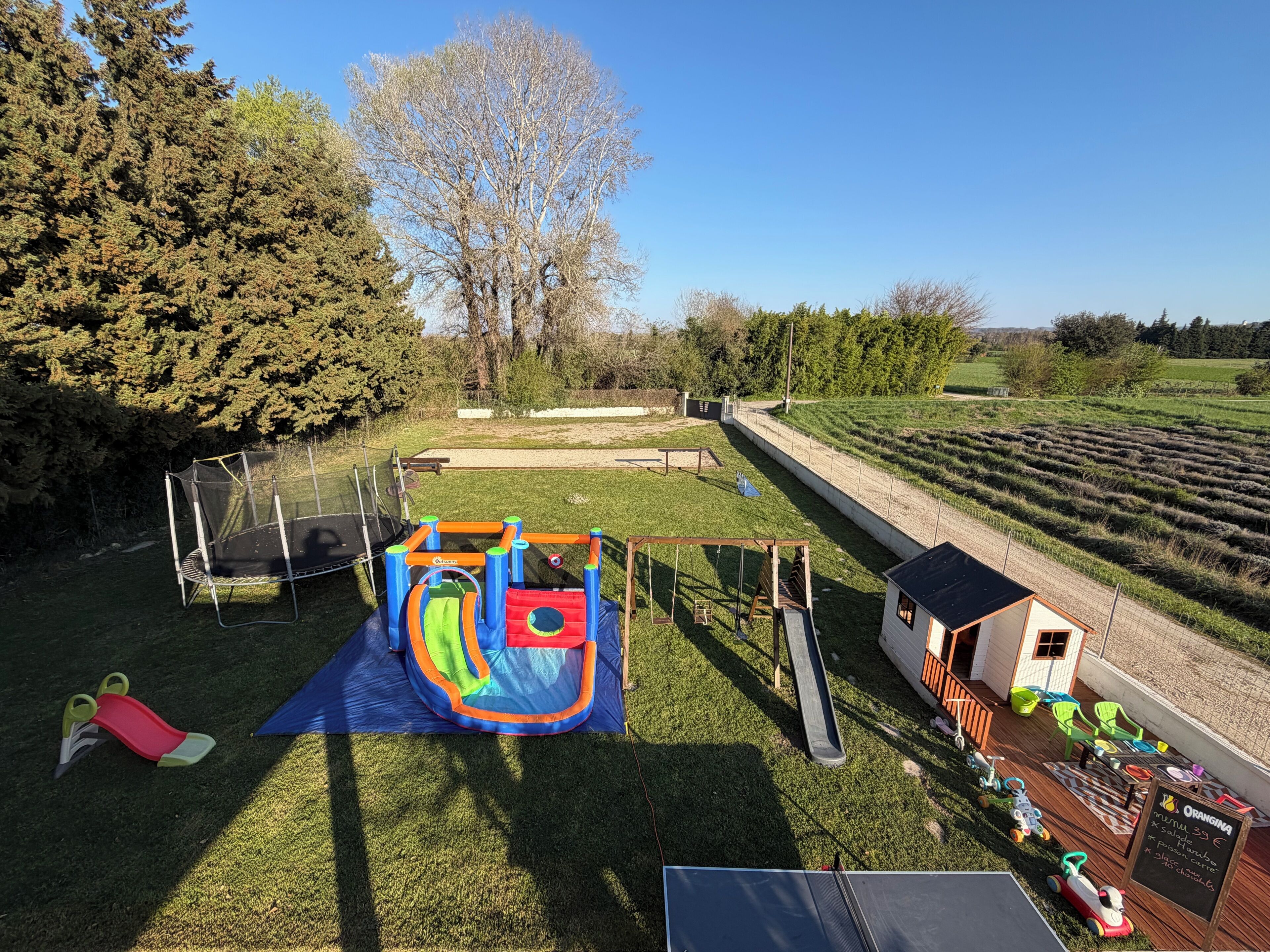 Une aire de jeux avec un toboggan, des balançoires et une structure d’escalade.