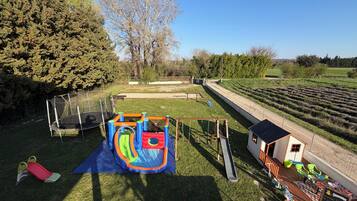 Une aire de jeux avec un toboggan, des balançoires et une structure d’escalade.