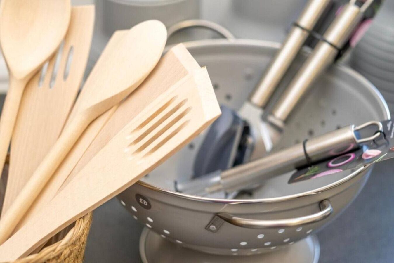 Un porte-ustensiles de cuisine contenant des cuillères en bois et un ustensile en métal.