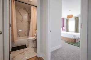 Een badkamer met een bad, toilet en marmeren vloer.