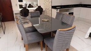 Un comedor moderno con una mesa de mármol, sillas tapizadas en gris y un suelo con diseño.