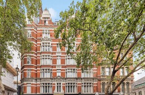 A historic building with a symmetrical facade, large windows, and ornate detailing. - Elegant Soho 2-bed, bright Victorian apartment with lift, walk to Covent Garden (London)