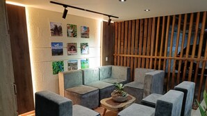 Een moderne zithoek met grijze banken en een houten salontafel.