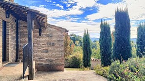 Ein Steinhaus mit einer Holztreppe und einem Backsteinportal.