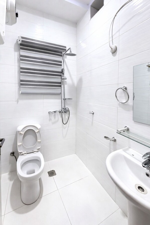 Un baño moderno con inodoro, ducha y lavabo.