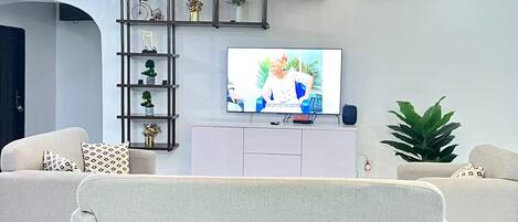Un soggiorno con tavolo da biliardo, televisione e lampadario.