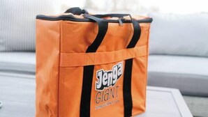 An orange bag with 'Jenya GIANI' text on it placed on a white table. - The Lofts @35th and Clay - Loft A (Garden City)