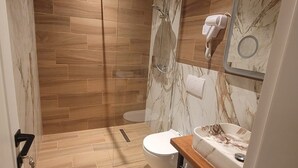 A modern bathroom with a shower, toilet, and vanity.