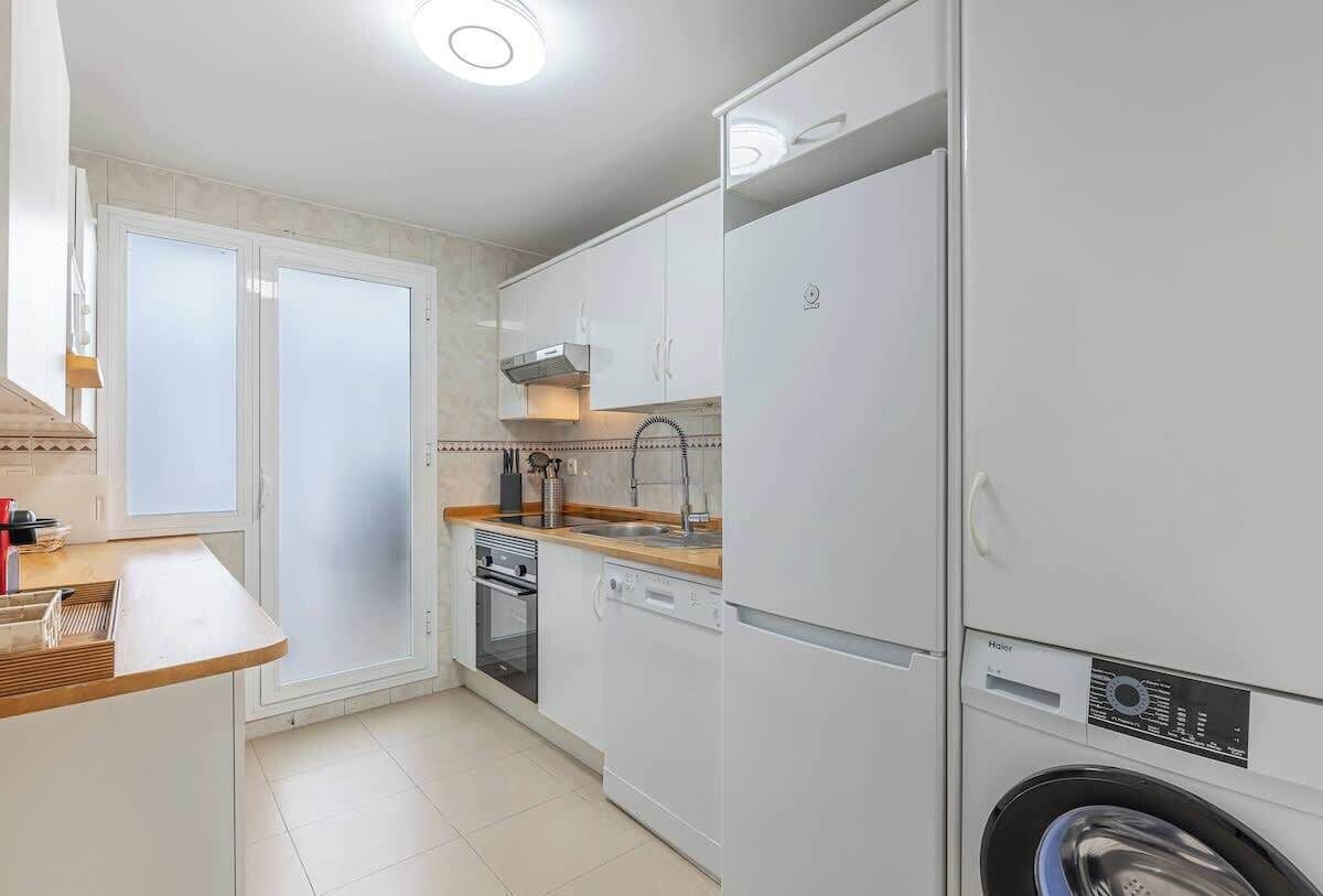 Una cocina compacta equipada con lavavajillas, horno y lavadora.