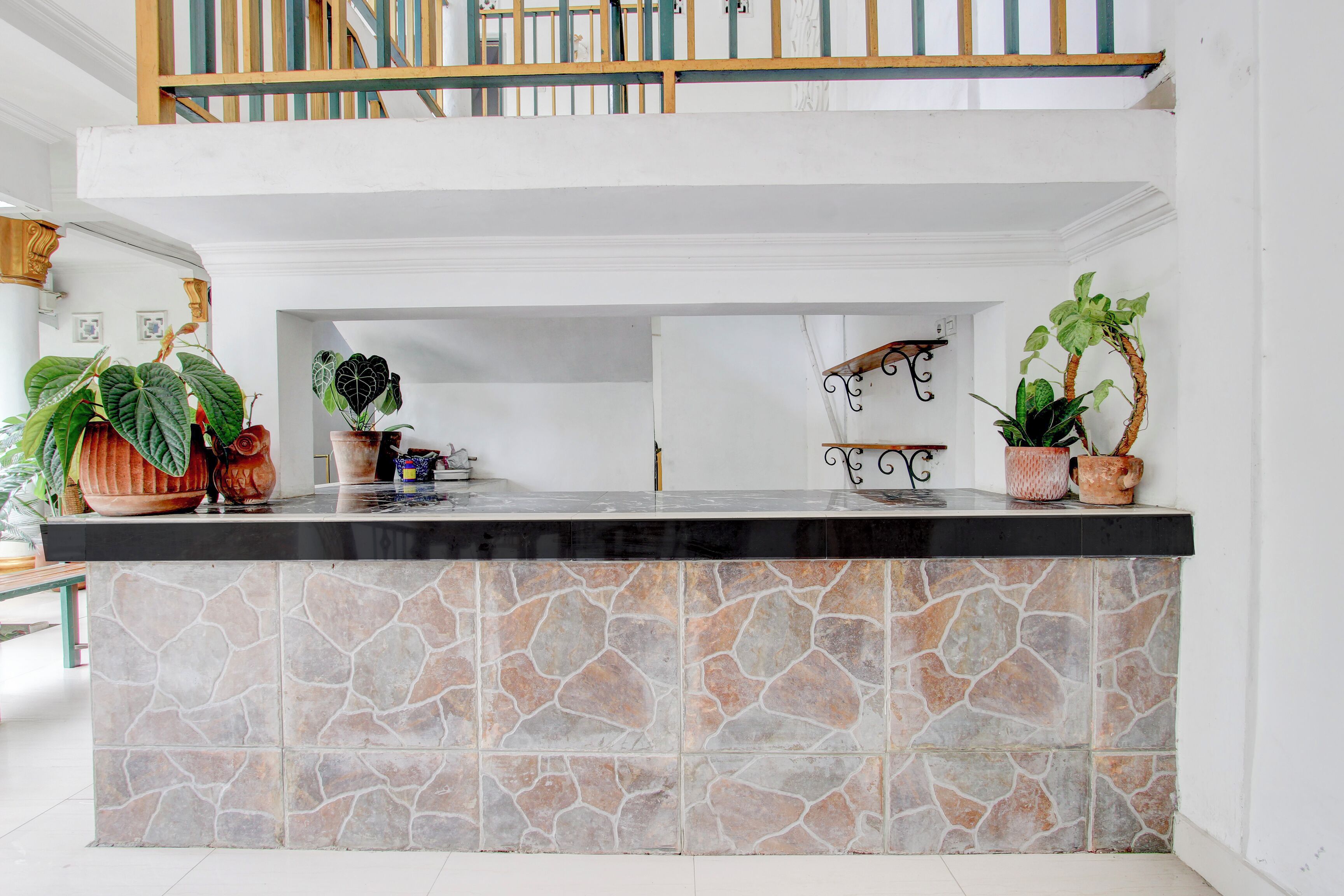 A kitchen with a stone backsplash, a wooden countertop, and potted plants.