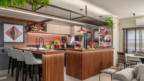 A modern kitchen with a central island, bar stools, and a dining area with a sofa. - Flat de 100m2 com Serviço de Camareira (Sao Paulo)