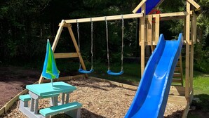 A wooden swing set with two swings and a blue slide. - Vacation with Dog – Holiday Home for up to 5 Guests (Friedrichroda)