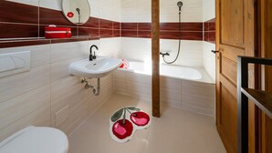 A bathroom with a white sink, a mirror, a red bag on the counter, a wooden door, and a shower area. - Nice American Diner Holiday apartment (Penig)