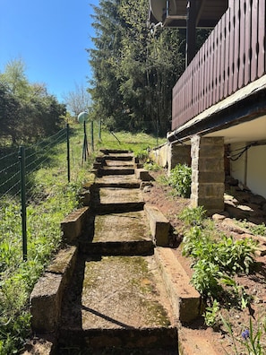 Eine Steintreppe führt zu einem Gebäude mit einem hölzernen Balkon.