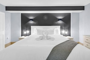 Ein modernes Hotelzimmer mit einem großen Bett, zwei Nachttischen, einem Kopfteil mit dekorativer Beleuchtung und einer Wandleuchte.
