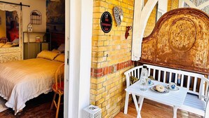 A room with a bed, a table with a plate of food, and a sign indicating a honeymoon suite. - Little Honeymoon Suite (Penig)