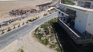 Una strada costiera con segnali di limite di velocità, una spiaggia e un edificio bianco con un balcone.