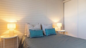 Una camera da letto con un letto, due abat-jour e un comodino.