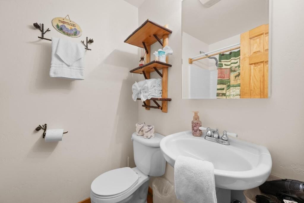 Et badeværelse med toilet, håndvask og håndklædestang.