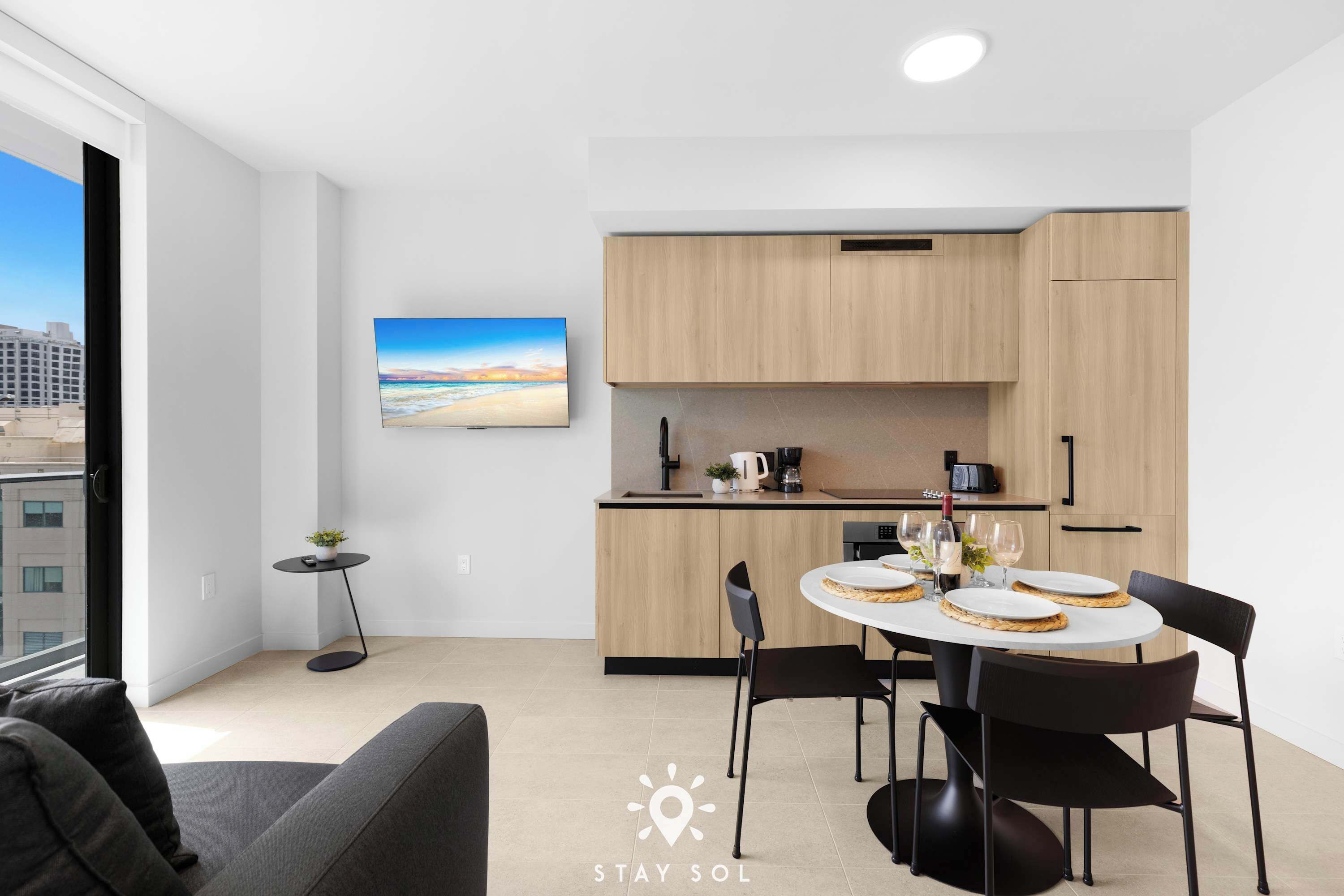 Une cuisine moderne avec un coin repas, une petite table d’appoint et un tableau accroché au mur.