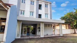 Un edificio moderno de dos pisos con un porche cubierto y un amplio ventanal.