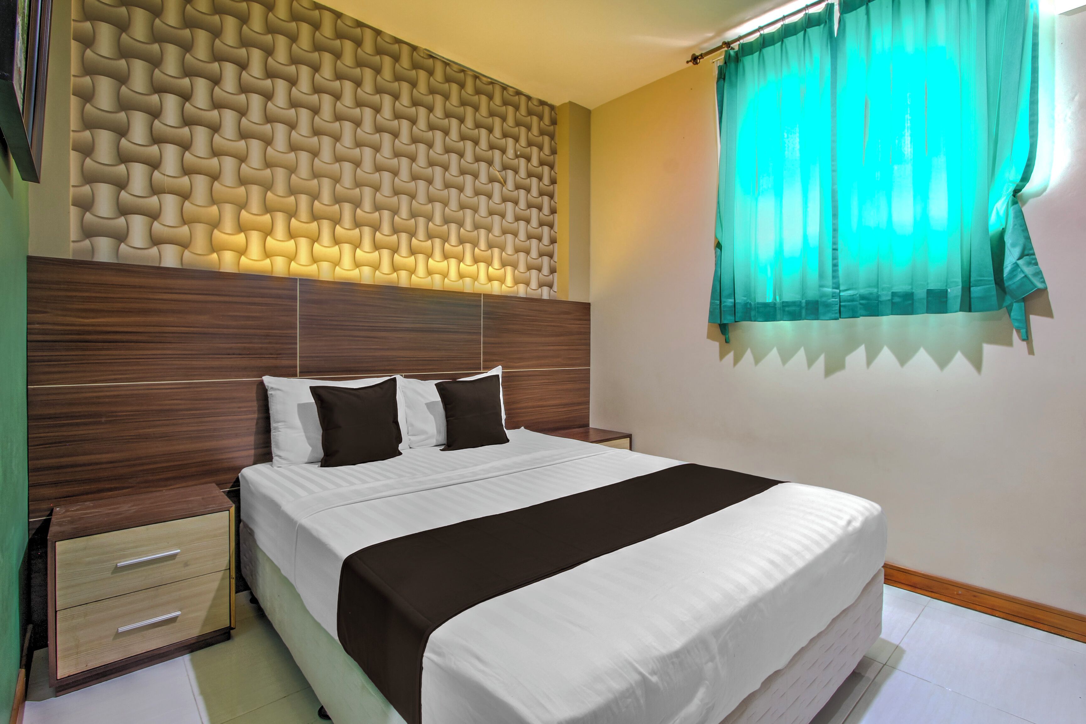 A neatly made bed with a headboard, a bedside table, and a wall with a textured pattern.