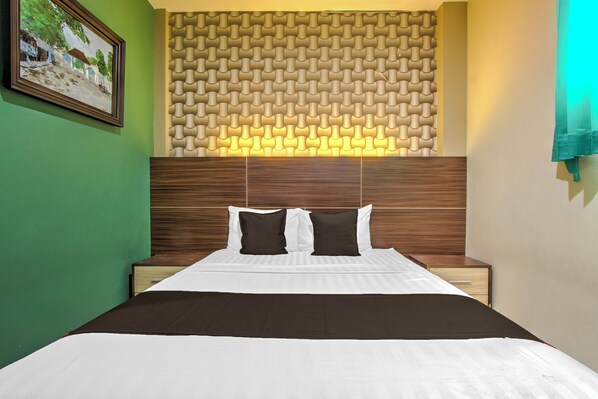 Un lit bien fait, avec une literie blanche et marron, une tête de lit en bois et un mur orné d’un motif.