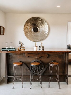 A bar area with a large decorative mirror, stools, and bar tools. - Lakeview Lodge • Remote Escape, 5-Acres, Pool, Spa (Joshua Tree)