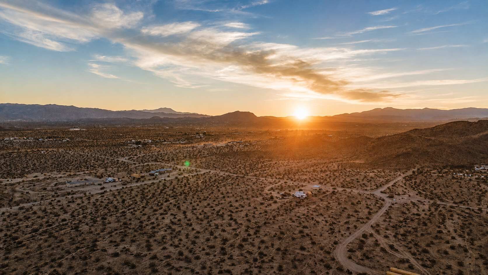 Vista aérea de un paisaje desértico con edificios dispersos y cielo despejado.