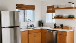 Eine moderne Küche mit Edelstahlgeräten, Holzschränken und einer Kaffeemaschine.